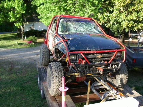 1985 Ford Bronco - This heavily modified truck features a prominent red roll cage and large off-road tires.