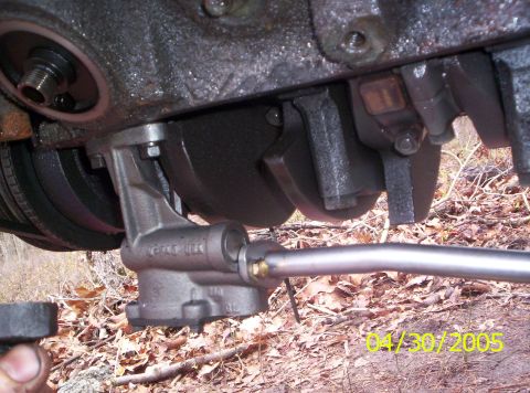 1985 Ford Bronco - Close-up view of an engine's oil pan and pickup tube assembly.
