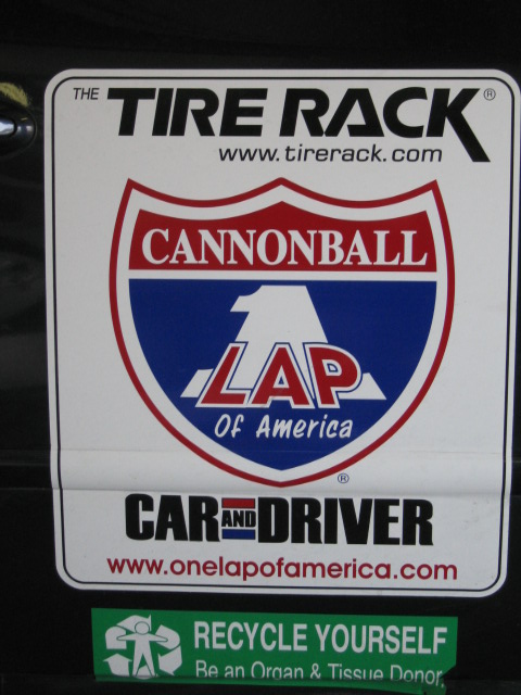 1991 Ford LTD Crown Victoria - A close-up view of several stickers affixed to a vehicle's exterior, including event and donation awareness decals.