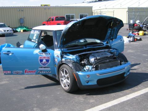 1991 Ford LTD Crown Victoria - A blue Mini Cooper with its hood and door open, revealing the engine and various racing decals on its side.