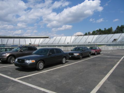 1991 Ford LTD Crown Victoria - A 1991 Ford Crown Victoria LTD is parked in a lot with other vehicles, with stadium seating visible in the background.