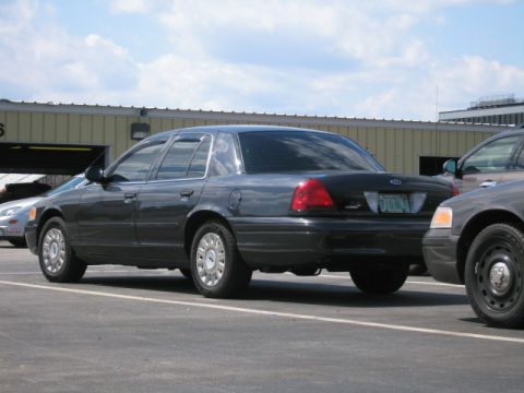1991 Ford LTD Crown Victoria - Rear view of a dark gray Ford Crown Victoria sedan parked in a lot.