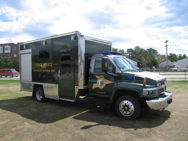 Green state police explosives disposal unit truck with "STATE POLICE" and "EXPLOSIVES DISPOSAL UNIT" text