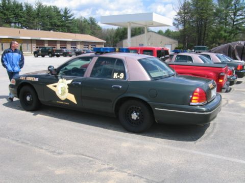 1991 Ford LTD Crown Victoria - A police car with K-9 markings is parked in a lot next to other vehicles.