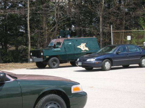 1991 Ford LTD Crown Victoria - An armored vehicle and two sedans are parked in an outdoor lot.