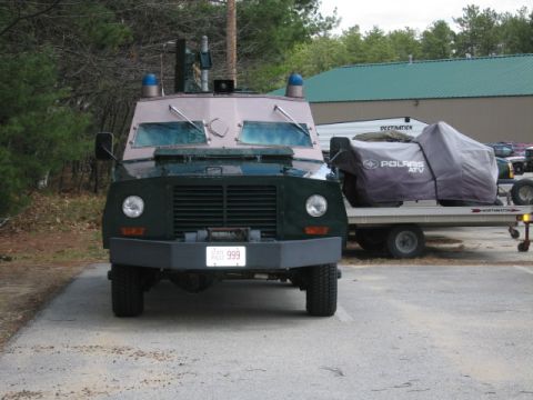 1991 Ford LTD Crown Victoria - A heavy-duty truck, possibly for law enforcement or security, is parked next to a trailer carrying a covered ATV.