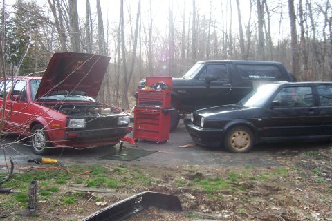 1996 Ford Bronco - A black Ford Bronco is parked next to two Volkswagen Golfs with hoods open.
