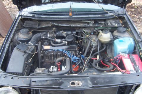1996 Ford Bronco - The engine bay of a car, showing various mechanical parts and wiring.