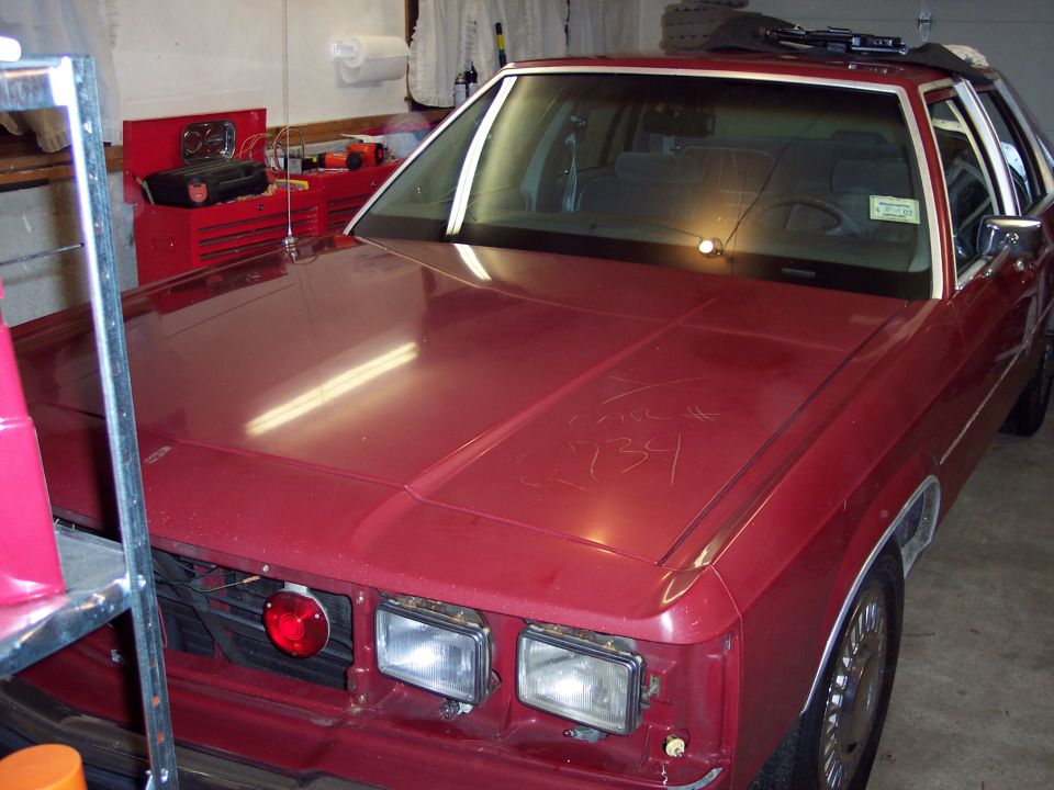Red 2001 Ford Crown Victoria front view with scribbled text on hood