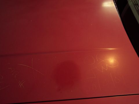 2001 Ford Crown Victoria - Scratched red car hood with handwritten text and a date.
