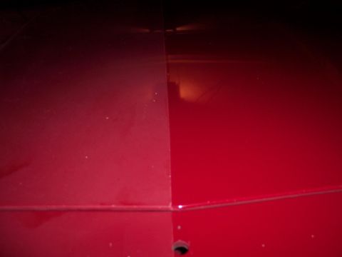 2001 Ford Crown Victoria - Red car hood detail with a prominent seam line.