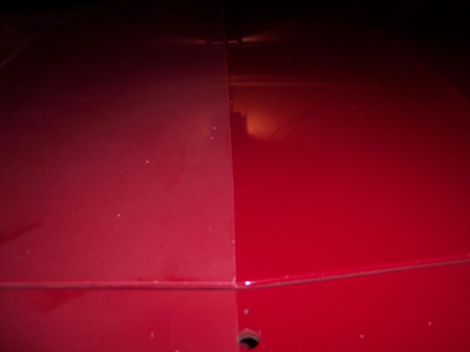 Close-up of a red car hood with a visible seam
