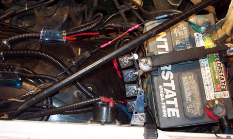 1985 Ford LTD Crown Victoria - Close-up of engine bay wiring and battery, showing relays and fuse box.