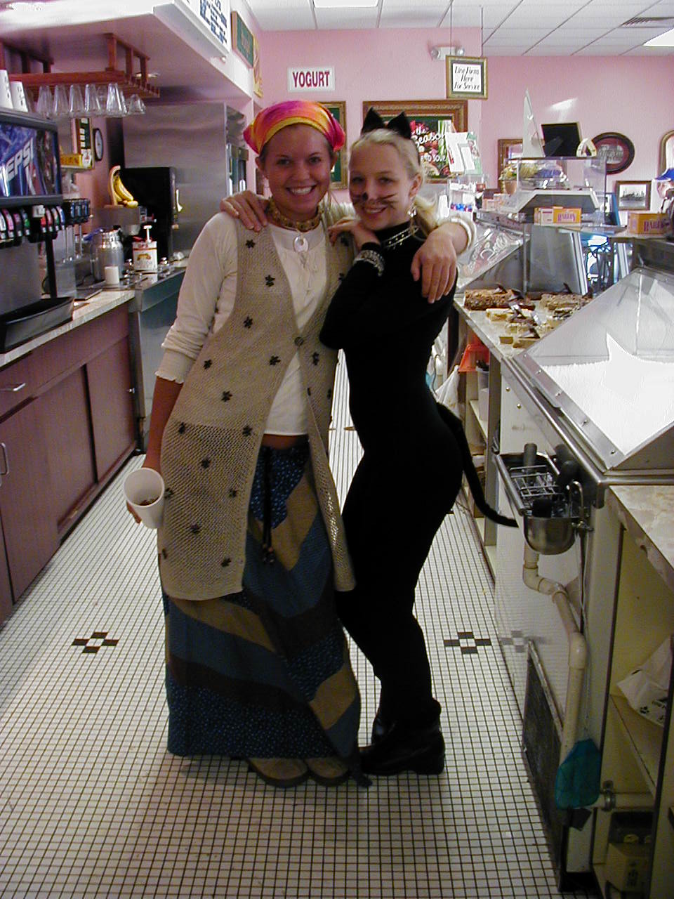 Woman in costume and friend pose in a yogurt shop