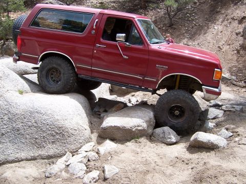 1991 Ford Bronco - This 1991 Ford Bronco is shown navigating a challenging rocky trail, demonstrating its off-road capabilities.