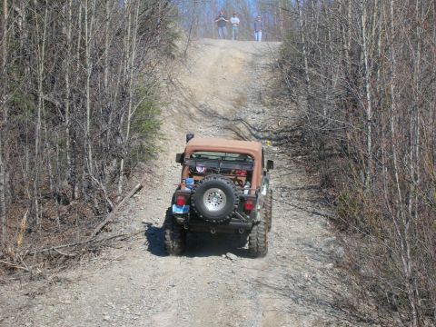 2003 Jeep TJ - Jeep TJ navigates a challenging off-road incline on a sunny day.