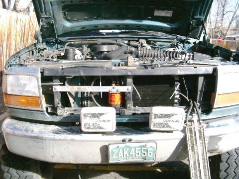 1996 Ford Bronco - New cooler installed onto aluminum bracket, biggest tranny cooler Hayden makes. Being held in place by cable ties while I install. The oil…