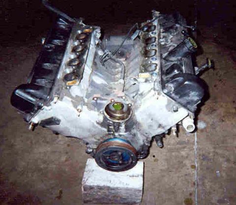 1992 Ford Crown Victoria - Engine block with intake manifold and pulley, likely removed from a vehicle for repair or replacement.