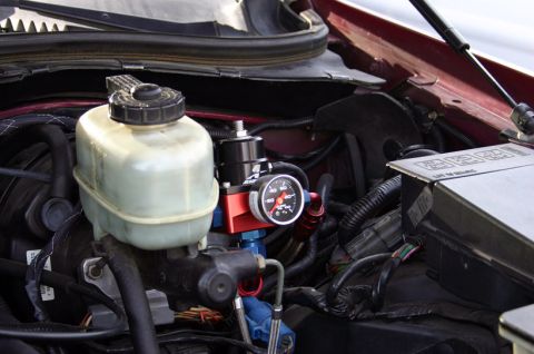 1992 Ford Crown Victoria - Close-up view of engine components, including a fuel pressure regulator and brake fluid reservoir.