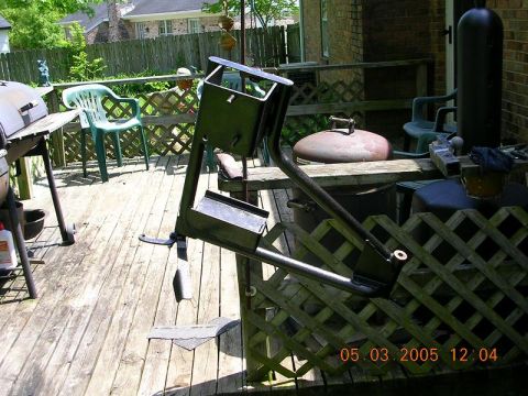1989 Ford Bronco II - Metal bracket assembly on a wooden deck, with a grill and chairs in the background.