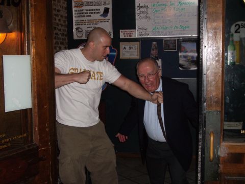 1995 Ford Bronco - Two men are interacting near a doorway, one grabbing the other's tie.