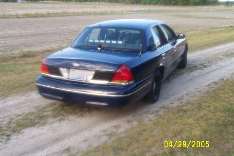 1998 Ford Crown Victoria - Rear view of a dark blue 1998 Ford Crown Victoria, equipped with police lights on the rear deck.