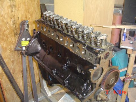 1985 Ford Bronco - An engine block is mounted on a stand in a workshop setting, ready for work.