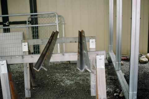 1976 Ford F-150 - Construction materials, including metal beams and framing, are staged outdoors near a gate.