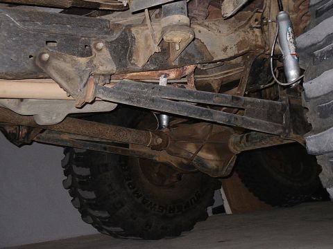 1996 Ford Bronco - Close-up of a vehicle's undercarriage, highlighting the suspension system and prominent off-road tires.