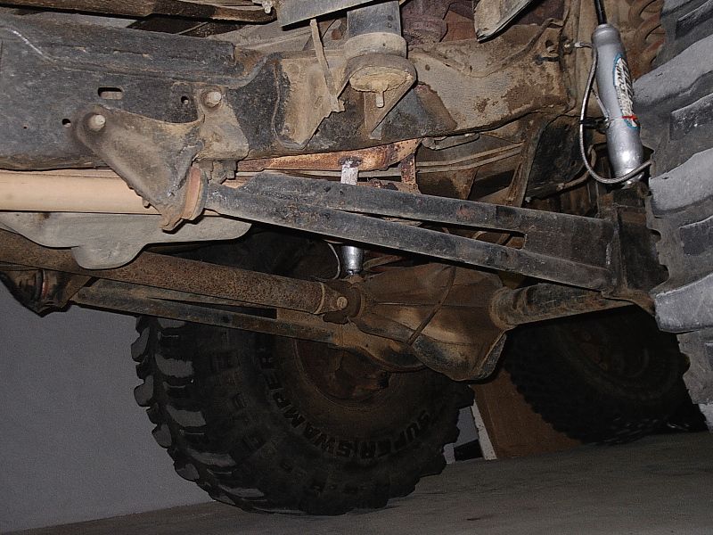 Undercarriage view of Bronco front axle, steering, and Super Swamper tire