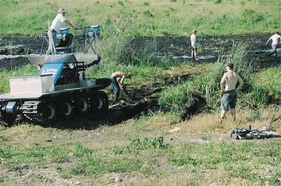 tracked vehicle with people digging in mud