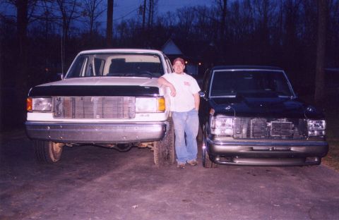 1989 Ford Bronco II - Man poses with his 1987 Ford F-150 and a Chevrolet pickup truck.