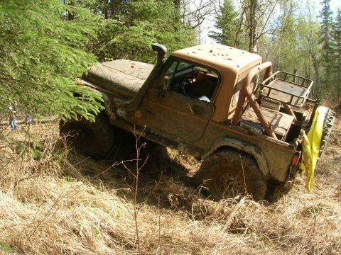 2003 Jeep TJ - Off-road vehicle navigates difficult terrain, getting stuck in brush and dry grass.