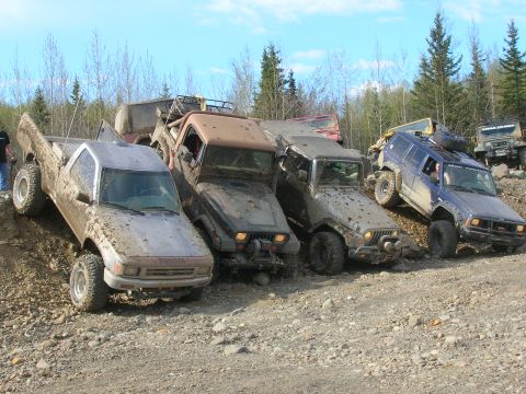 2003 Jeep TJ - A group of off-road vehicles, including a Toyota pickup and several Jeeps, tackle a challenging rocky terrain.