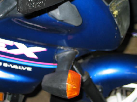 Blue Kawasaki motorcycle fairing with EX graphics and amber turn signal
