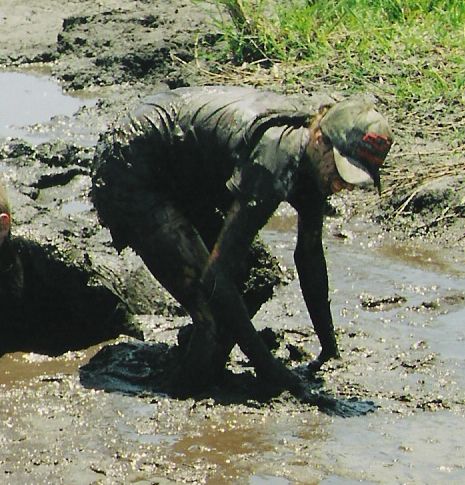 1992 Ford Bronco - A person is covered in mud while participating in a mud pit event.
