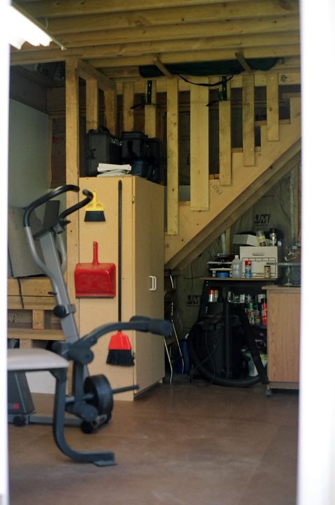 1976 Ford F-150 - The unfinished interior of a workshop space with exercise equipment and storage.
