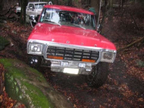 1978 Ford Bronco - 1978 Ford Bronco navigating a rocky, wooded trail with another vehicle in the background.