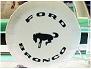 1995 Ford Bronco - A spare tire cover displaying the Ford Bronco branding, including the iconic horse emblem and text.