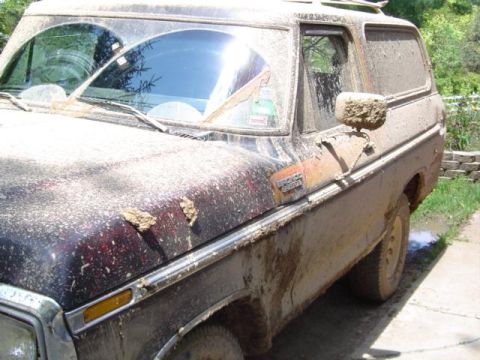 1979 Ford Bronco - This mud-covered 1978 Ford Bronco is seen from the front three-quarter angle, with significant dirt obscuring its details.