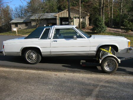 1985 Ford Crown Victoria LTD - White 1985 Ford Crown Victoria LTD being transported on a trailer.