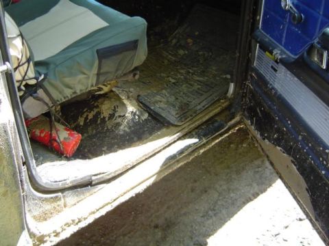 1979 Ford Bronco - The interior of a vehicle is covered in mud, suggesting recent off-road use.