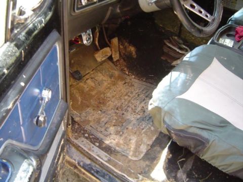 1979 Ford Bronco - The interior of this vehicle is heavily soiled with mud and dirt on the floor mats and surrounding areas.