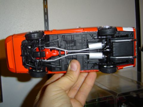 1979 Ford Bronco - Underside view of an orange model car, displaying its chassis and drivetrain components.