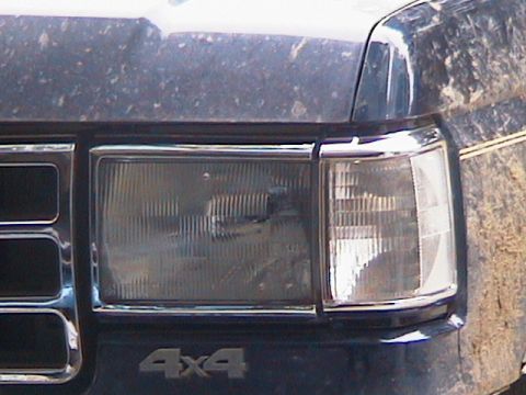 1991 Ford Bronco - The front of a dark blue 1991 Ford Bronco shows its "4x4" emblem and chrome accents.