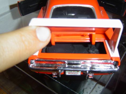 1979 Ford Bronco - Close-up of an orange toy car's open trunk, showing the interior and a license plate.