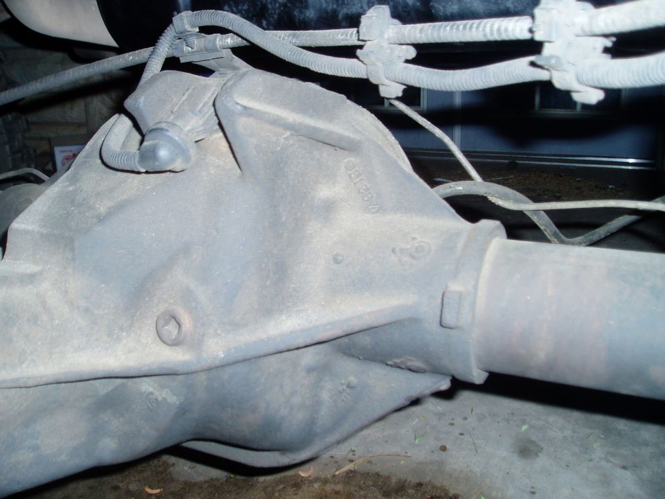 Gray rear differential housing with brake lines and electrical conduit attached