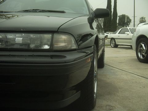 1989 Mazda MX-6 - A black sedan is parked in a lot with other vehicles visible in the background.