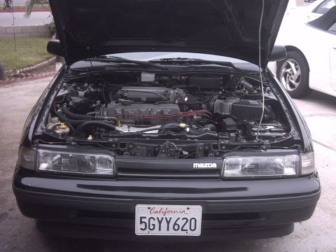 1989 Mazda MX-6 - Front view of a 1989 Mazda MX-6 with the hood open, showing the engine bay.