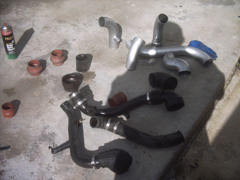 1989 Mazda MX-6 - Collection of intake pipes and hoses, possibly for a performance upgrade, with a can of brake cleaner.